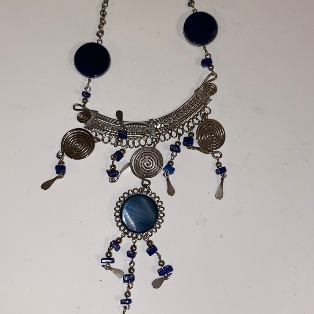 Ornate Silver-Toned Necklace with a Curved Center Adorned with Blue/Black Stones